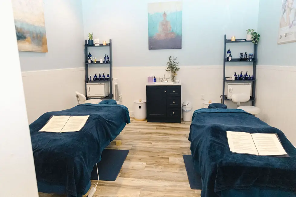 Two massage tables side by side under navy linens in the couples room