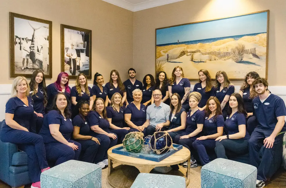The full Avenue Apothecary & Spa team seated together in navy scrubs